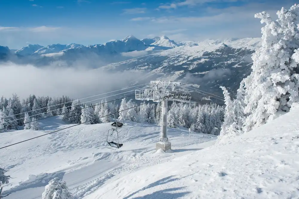 Verschneite Sesselbahn auf der Mutta oberhalb von Feldis mit Blick auf die Bündner Bergwelt
